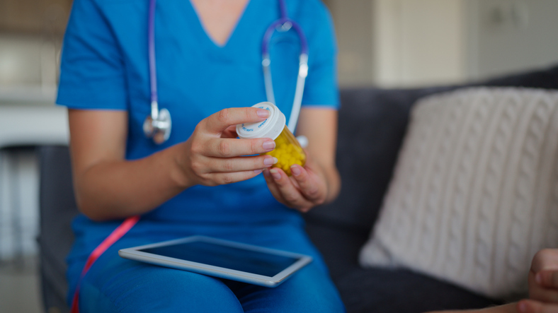Nurse Handing Medication Bottle to Father During Discussion